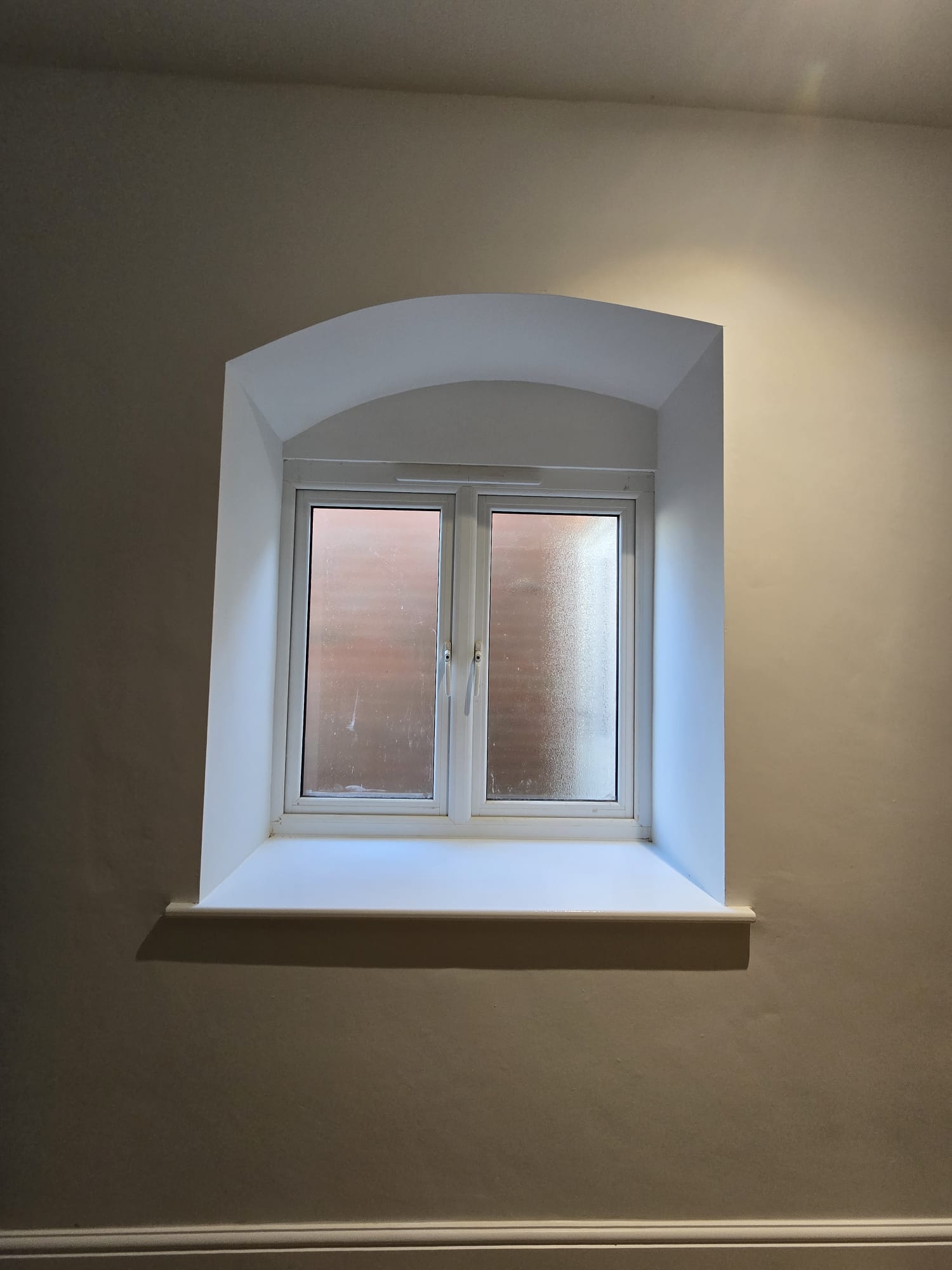 Repainted arched window reveal, new build