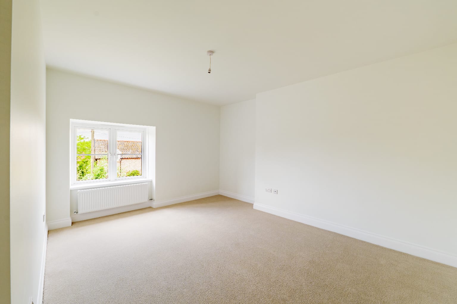 Freshly painted new-build bedroom with exposed oak beams